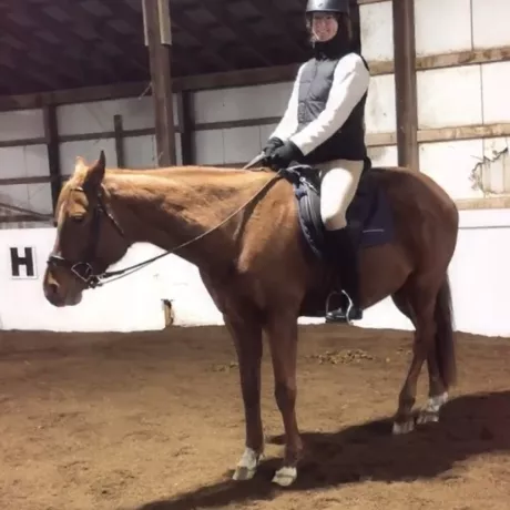 A volunteer rider mounted on Tia in our indoor arena. 
