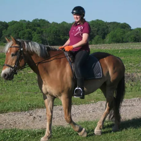 A rider riding Lexie outside in the back fields of our property in the summer time. 