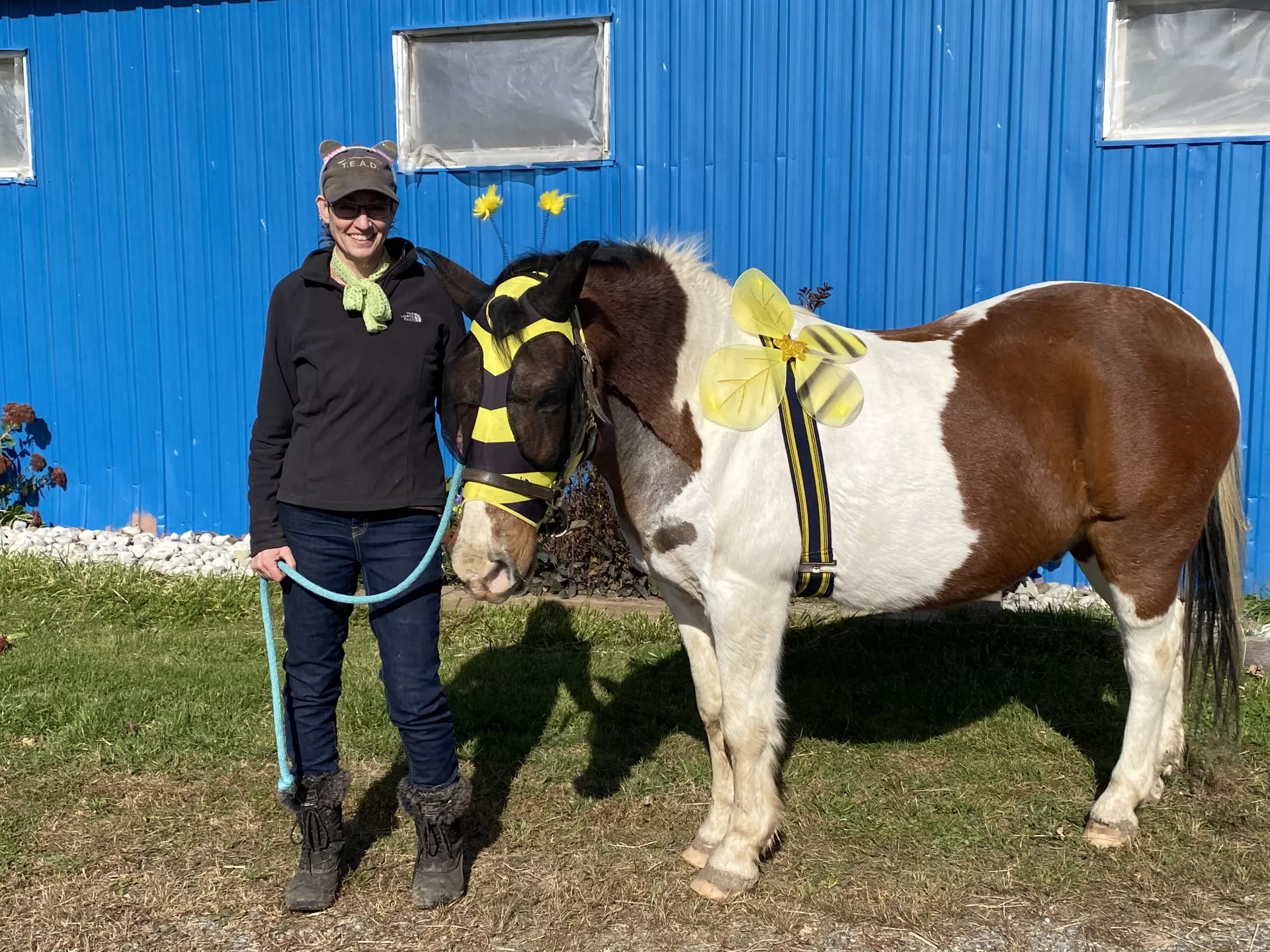 Rachael standing outside the barn with Wrangler, dressed as a bumblebee